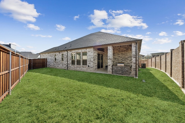 back of house featuring a patio area, a fenced backyard, a lawn, and brick siding