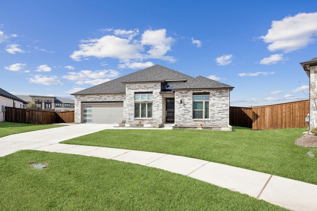 prairie-style home with a shingled roof, concrete driveway, a front yard, fence, and a garage