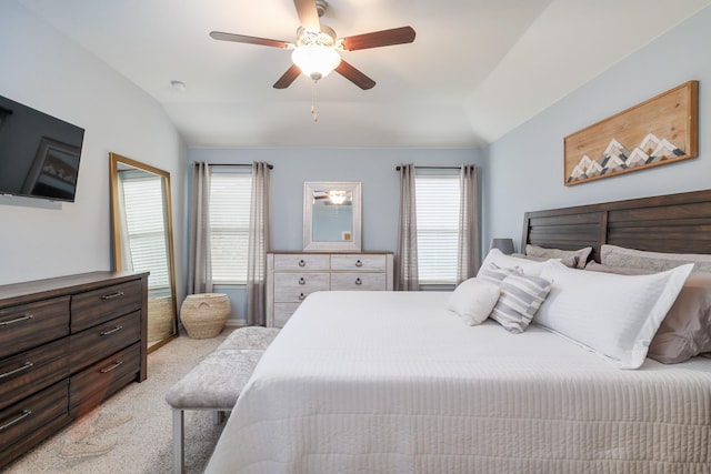 bedroom featuring ceiling fan, light carpet, vaulted ceiling, and multiple windows