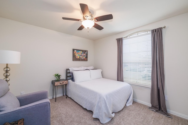 bedroom featuring light carpet, ceiling fan, and baseboards