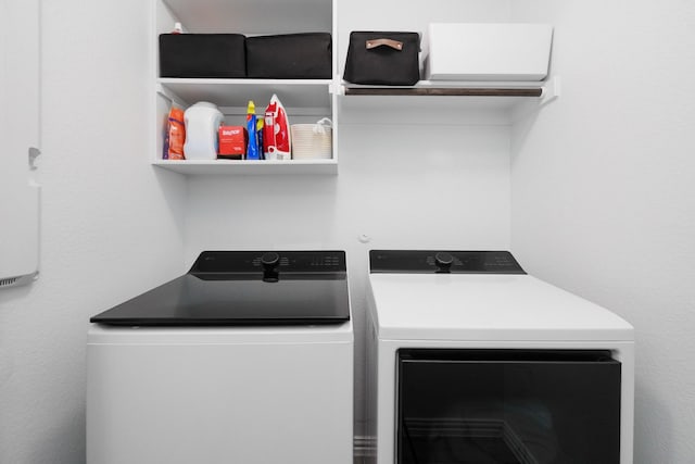 clothes washing area featuring laundry area and washer and clothes dryer