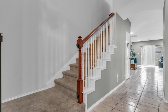 stairway with visible vents, baseboards, and tile patterned floors