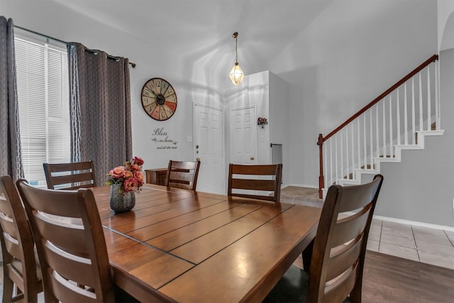 tiled dining room with baseboards and stairs