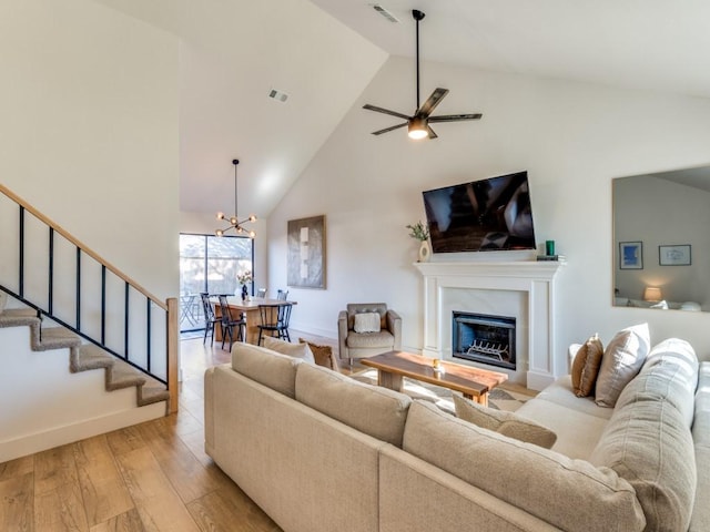 living room with visible vents, a fireplace, stairway, and light wood finished floors