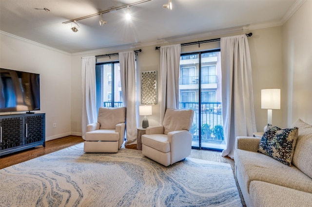 living area with baseboards, wood finished floors, and crown molding