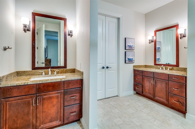 bathroom with two vanities, baseboards, and a sink