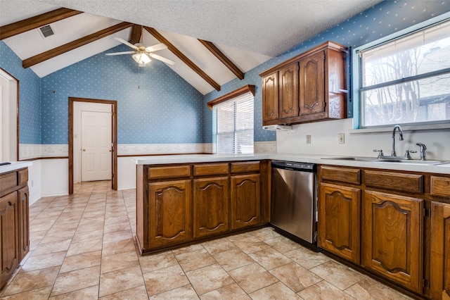 kitchen featuring a sink, wallpapered walls, a textured ceiling, and dishwasher