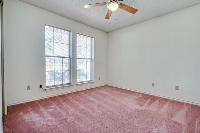 carpeted spare room featuring a textured ceiling and a ceiling fan