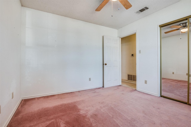 unfurnished bedroom featuring a closet, visible vents, ceiling fan, and carpet flooring