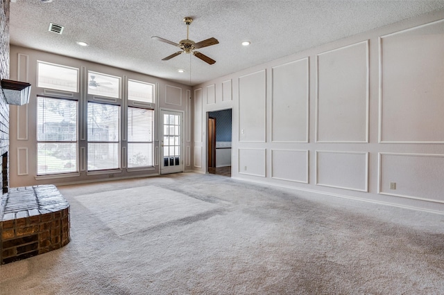 unfurnished living room with carpet floors, a healthy amount of sunlight, visible vents, and a decorative wall