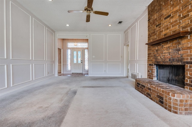 unfurnished living room featuring carpet floors, visible vents, and a decorative wall