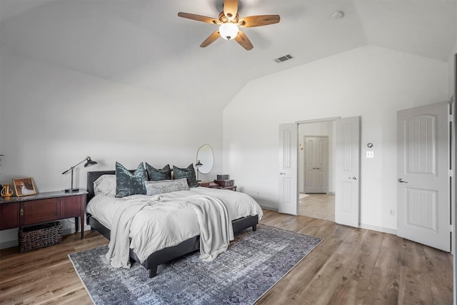 bedroom with high vaulted ceiling, a ceiling fan, visible vents, and wood finished floors