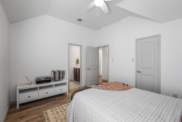 bedroom with lofted ceiling, ceiling fan, ensuite bathroom, wood finished floors, and visible vents