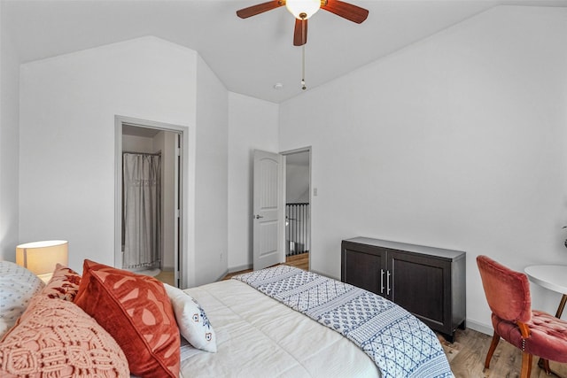 bedroom with lofted ceiling, light wood finished floors, and baseboards