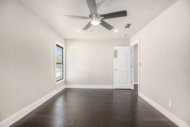 spare room featuring visible vents, baseboards, and dark wood-type flooring