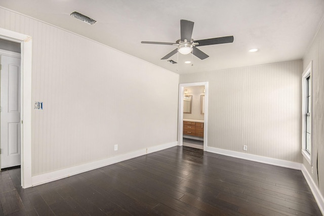 unfurnished bedroom with ceiling fan, connected bathroom, dark wood-style flooring, visible vents, and baseboards