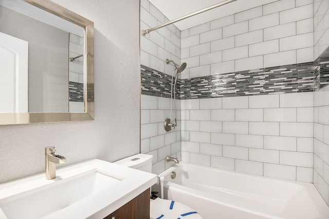 bathroom with a textured wall, shower / bathing tub combination, vanity, and toilet