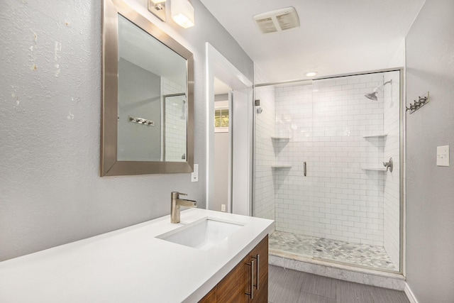 full bath with vanity, a shower stall, and visible vents