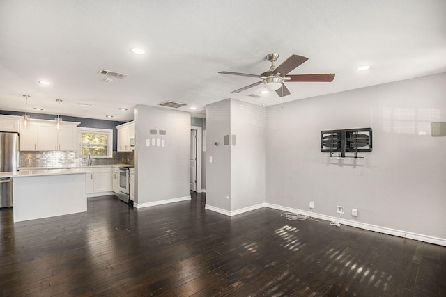 unfurnished living room with baseboards, visible vents, dark wood-style flooring, and a sink