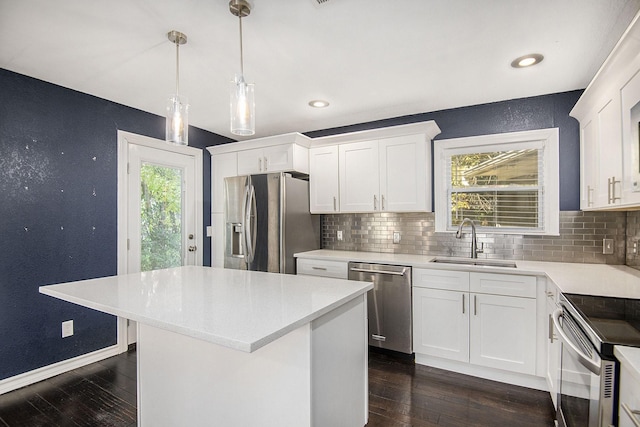 kitchen featuring decorative backsplash, dark wood-type flooring, stainless steel appliances, light countertops, and a sink