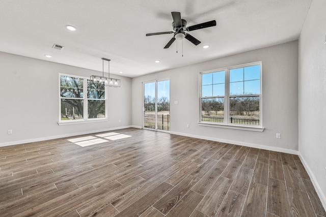 empty room with recessed lighting, visible vents, dark wood finished floors, and baseboards