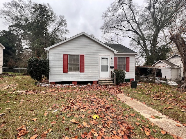 bungalow-style house with entry steps and fence