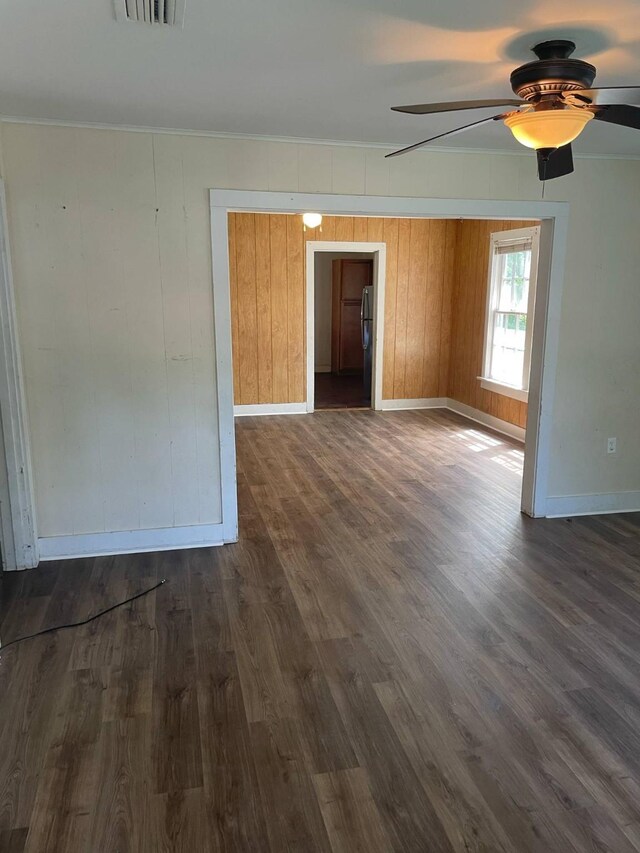 209 S Roosevelt St, Minden, LA 71075 - unfurnished room featuring baseboards, dark wood-type flooring, a ceiling fan, crown molding, and wooden walls