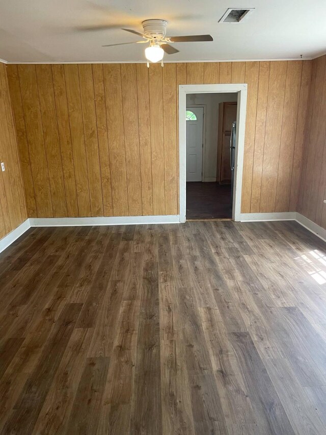 209 S Roosevelt St, Minden, LA 71075 - unfurnished room with a ceiling fan, dark wood-type flooring, wood walls, and baseboards