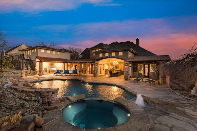 view of swimming pool with a patio area, a pool with connected hot tub, stairway, and an outdoor living space