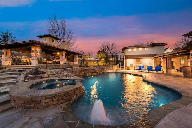 pool at dusk with stairs, a patio area, fence, and a pool with connected hot tub