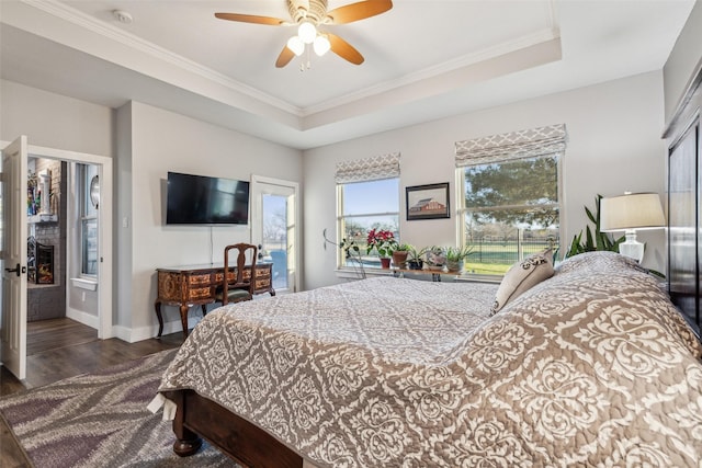 bedroom featuring crown molding, baseboards, a raised ceiling, and dark wood-type flooring