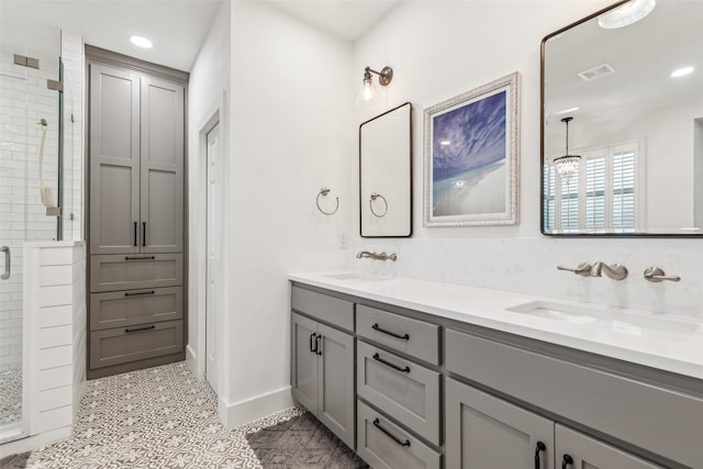 bathroom featuring a stall shower, visible vents, a sink, and double vanity