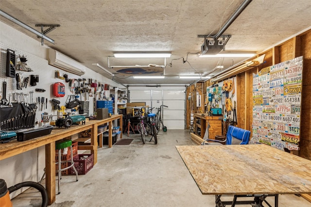 garage featuring a workshop area and a wall mounted AC