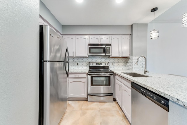 kitchen featuring stainless steel appliances, a sink, backsplash, and light stone counters