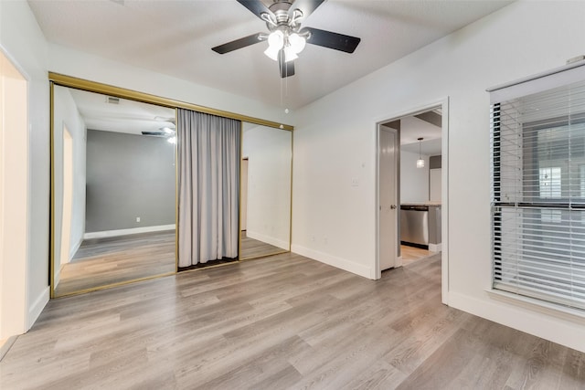 empty room with light wood-style floors, visible vents, ceiling fan, and baseboards