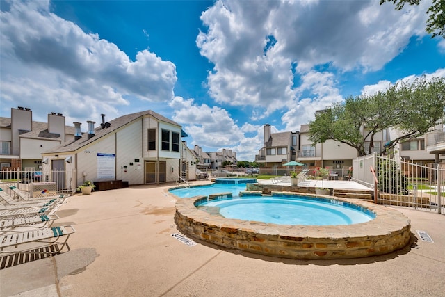 view of swimming pool with a patio area, fence, and a residential view