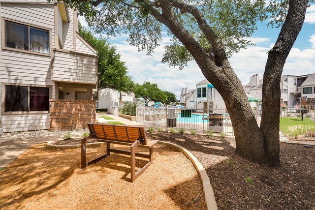 view of yard featuring a residential view, fence, a fenced in pool, and a patio