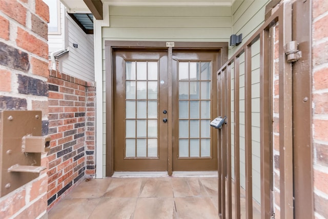 property entrance with brick siding and french doors