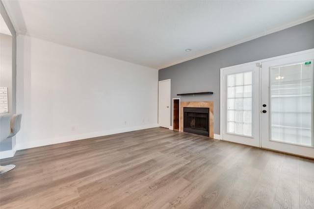 unfurnished living room with crown molding, baseboards, and wood finished floors