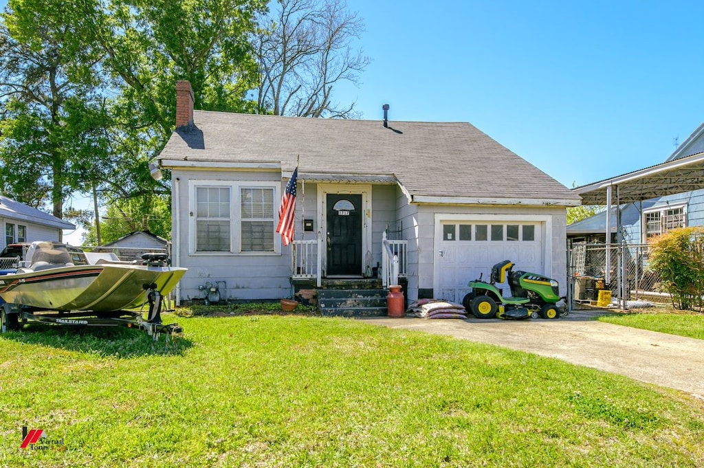 view of front facade featuring a garage, fence, concrete driveway, a chimney, and a front yard