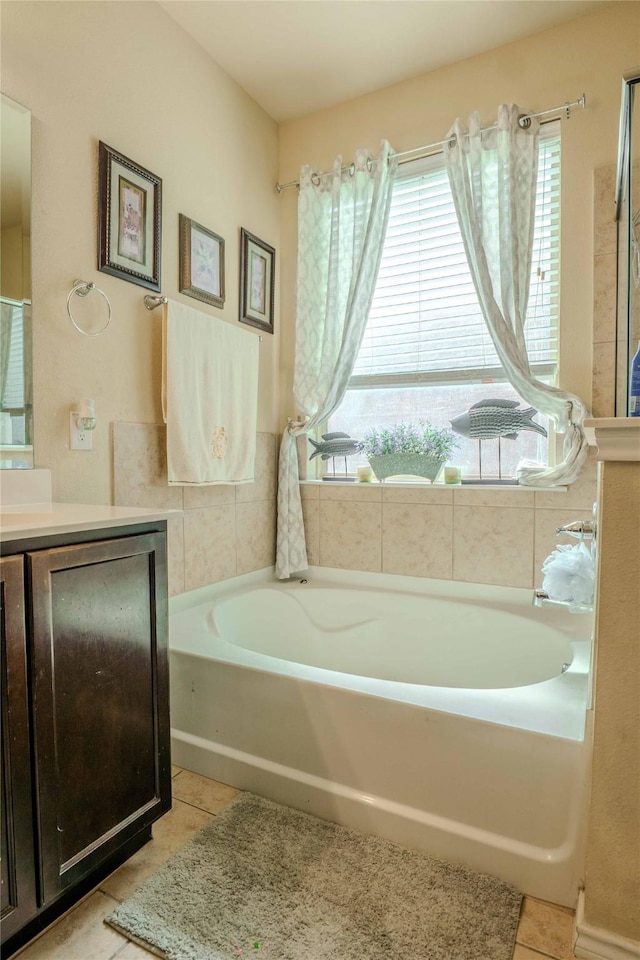 bathroom featuring a garden tub, tile patterned flooring, and vanity