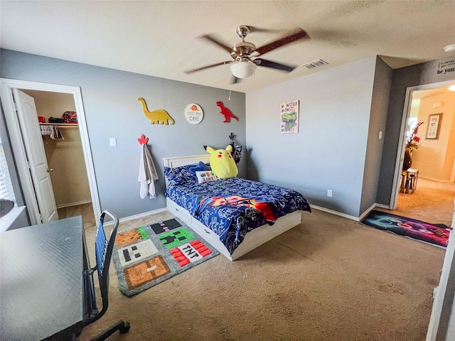 carpeted bedroom with ceiling fan, a textured ceiling, visible vents, and baseboards