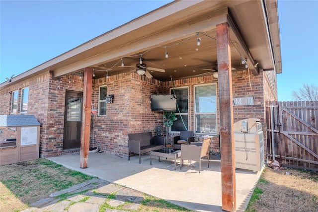 view of patio featuring ceiling fan, fence, and an outdoor living space