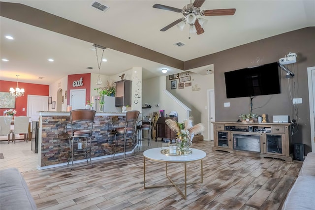 living room featuring recessed lighting, visible vents, light wood finished floors, and ceiling fan with notable chandelier