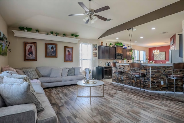 living area with recessed lighting, visible vents, light wood-style floors, vaulted ceiling, and ceiling fan