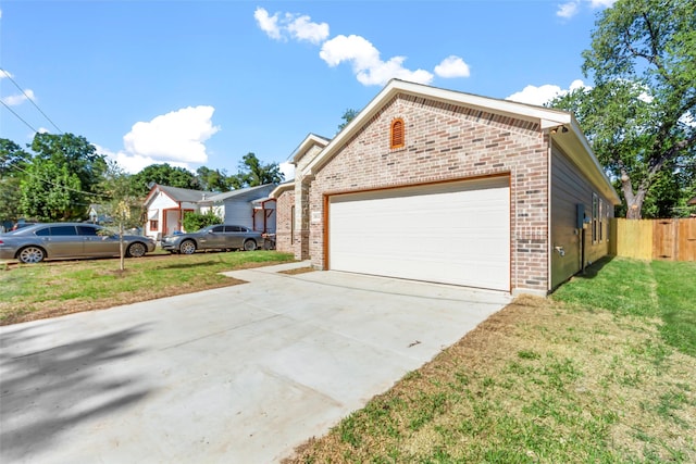 view of front facade with driveway, fence, and brick siding