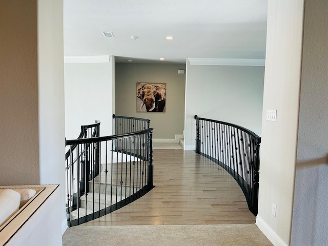 hallway featuring crown molding, light wood finished floors, an upstairs landing, and baseboards