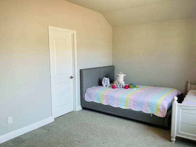 bedroom with lofted ceiling, carpet, and baseboards