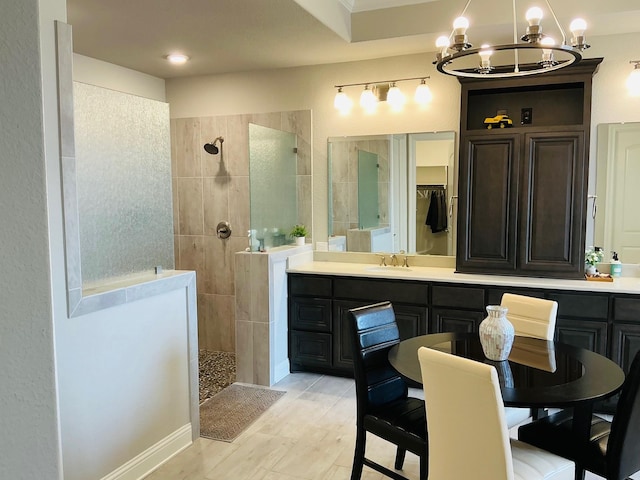 bathroom with a chandelier, walk in shower, and vanity