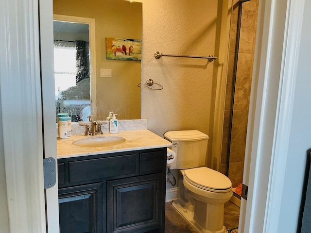 full bath with a textured wall, a shower stall, toilet, and vanity